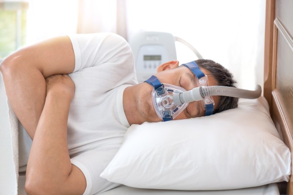 A person sleeps with a sleep apnea device
